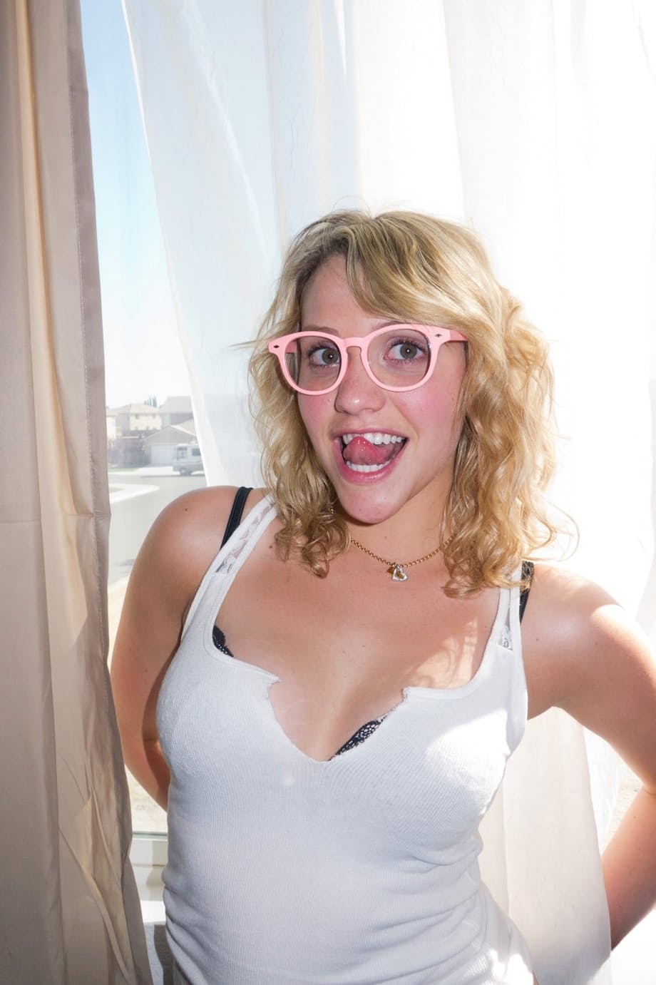 Blonde teen Mia Malkova models non nude in jeans shorts on top of a motorcycle