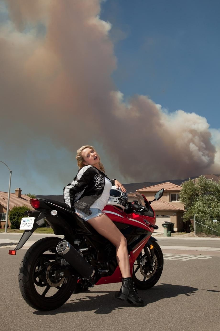 Blonde teen Mia Malkova models non nude in jeans shorts on top of a motorcycle