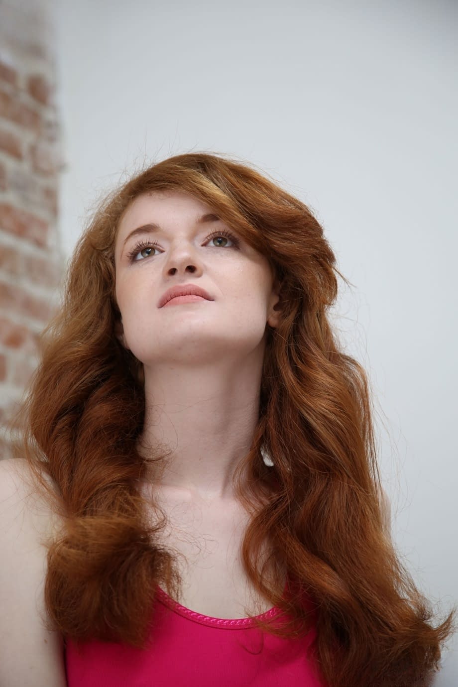 Leggy redhead cheater Abbey Rain strips while watching porn in gloryhole room