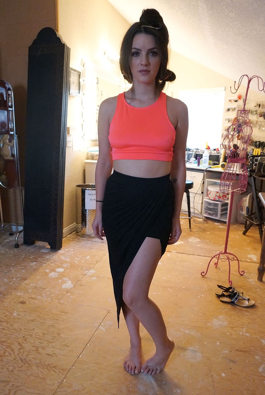 Brunette girl Kacey Quinn takes off a black dress while modelling solo