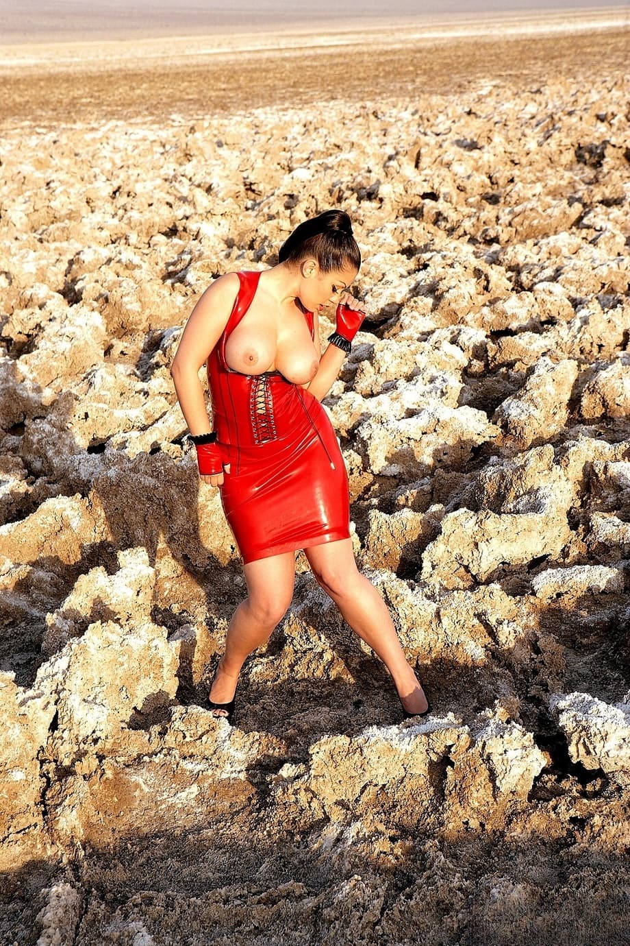 Goth model Aria Giovanni works free of a latex dress in deserted lands