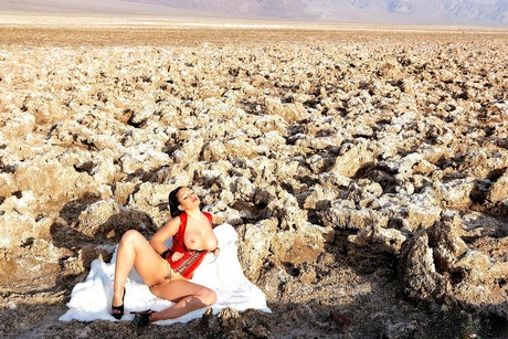 Goth model Aria Giovanni works free of a latex dress in deserted lands