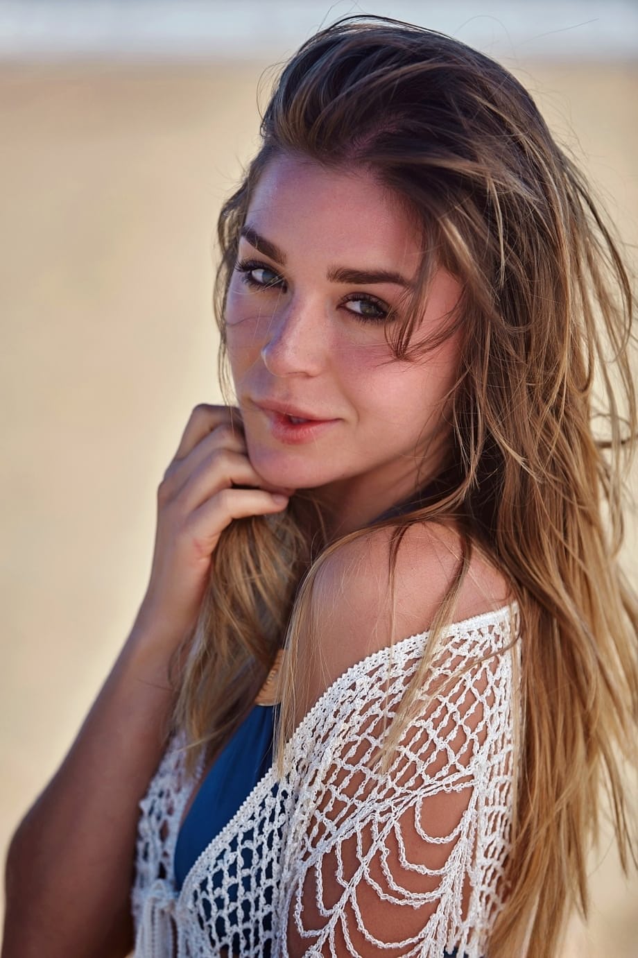 Erotic centerfold Lily C removes bikini to pose nude on driftwood at the beach