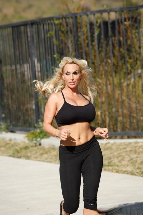 Busty blonde Holly Halston wets big tits while exercising clothed outdoors