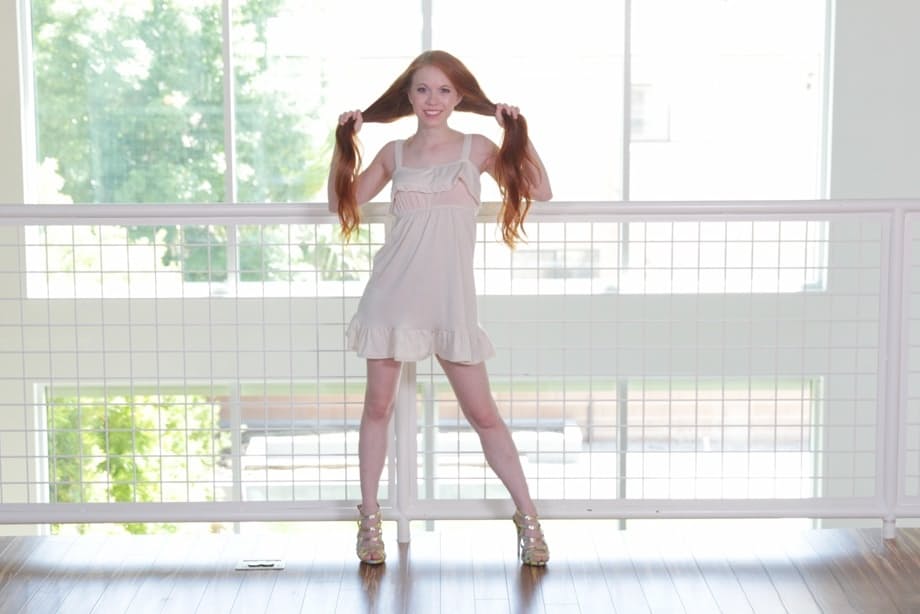 Foxy redhead Dolly Little stripping and playing with her pussy lips
