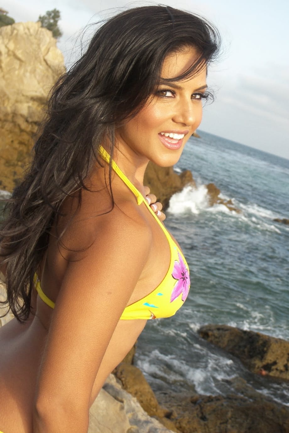 Brunette temptress Sunny Leone exposes herself on the rocky beach