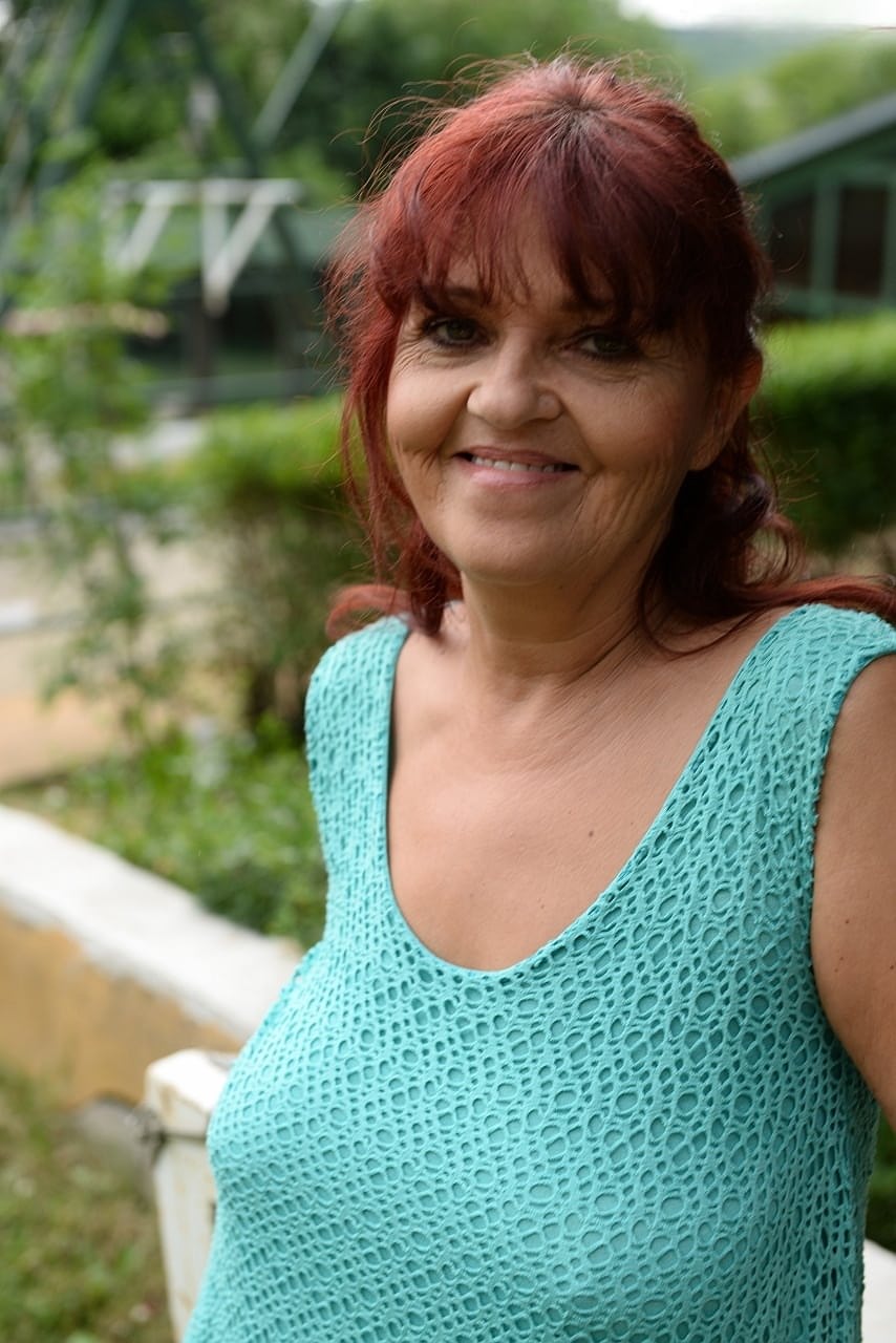 Redhead granny Livia lifts her blue dress up and reveals big natural tits