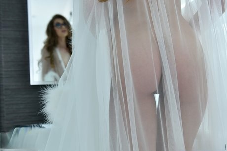 Glasses clad Russian stunner Elena Koshka poses erotically in sheer lingerie