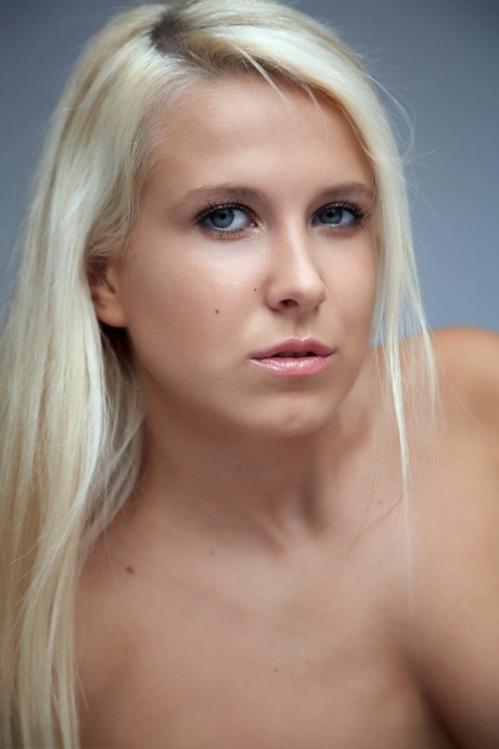 Blonde girl with long hair and medium breasts models in the nude