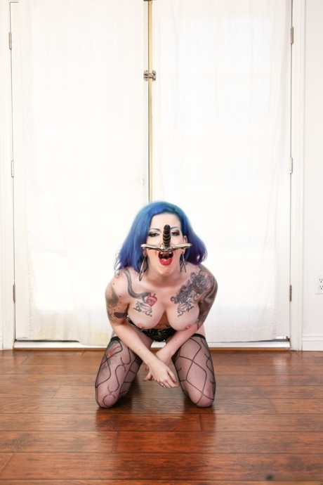 Busty inked Penny Poison performs sexy swordplay naked in black stockings