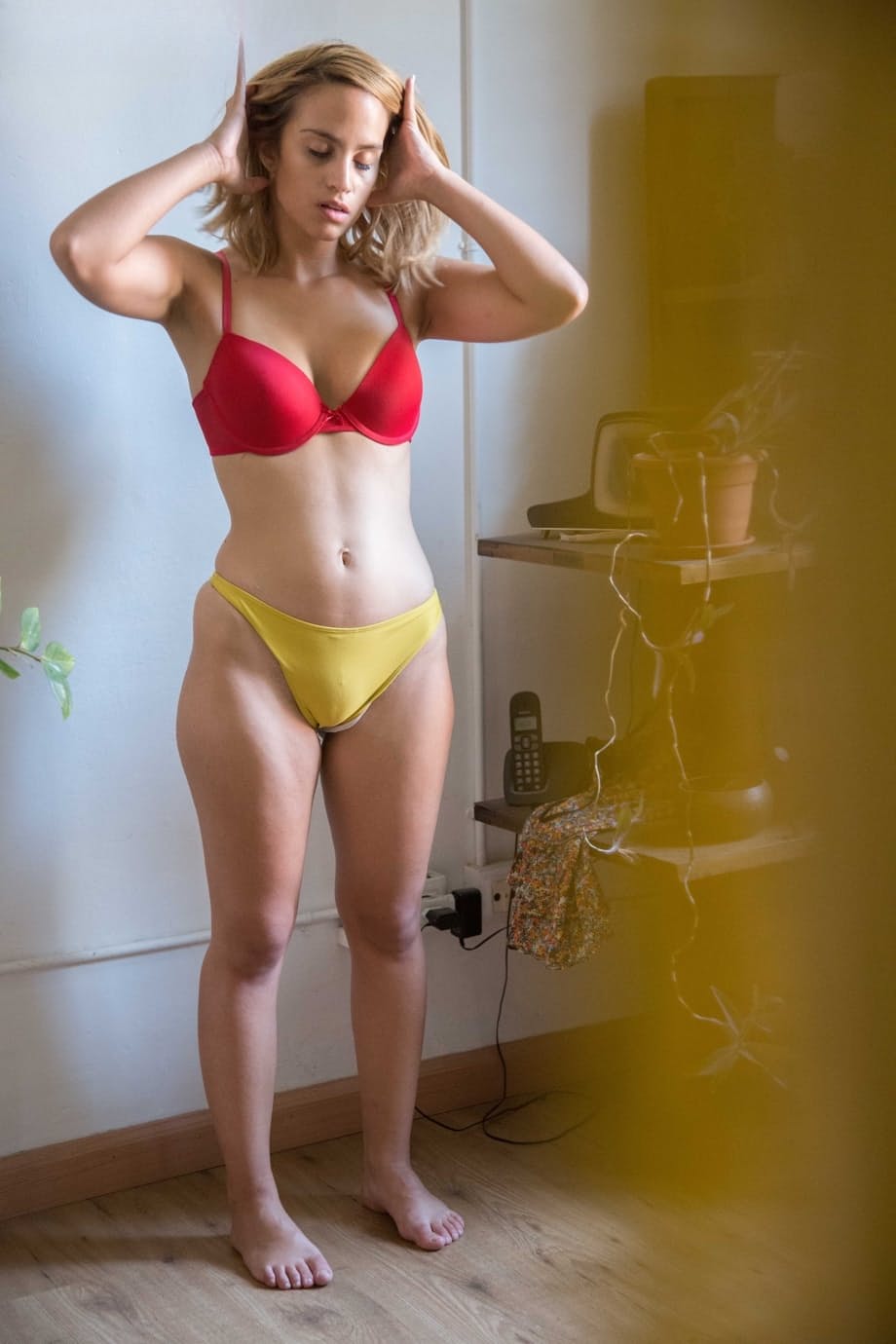 Naked white chick pulls on her bra and panties as she gets dressed