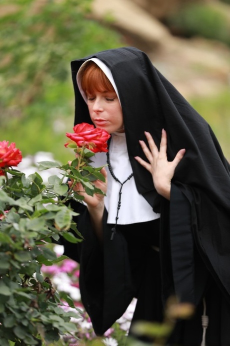 Redheaded nun Penny Pax shows off her big natural boobs and twat