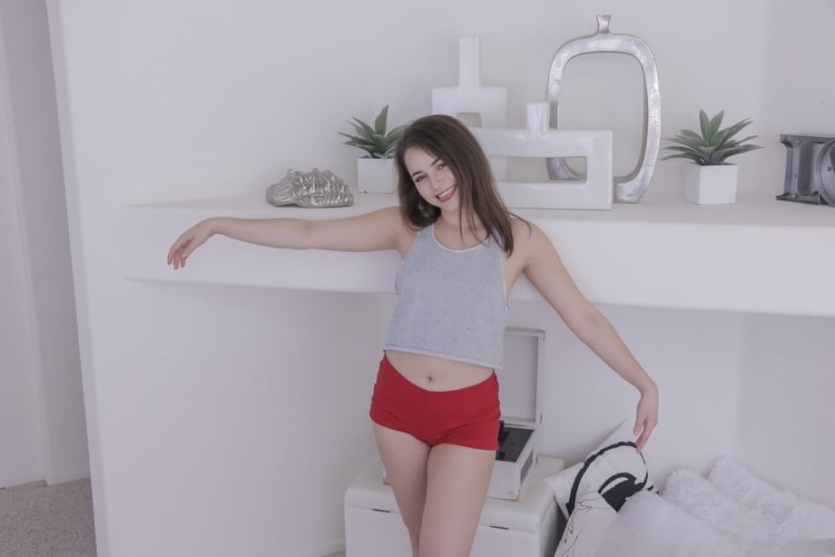Cute young teen Kylie Quinn in sexy red shorts gazes upward during POV blowjob