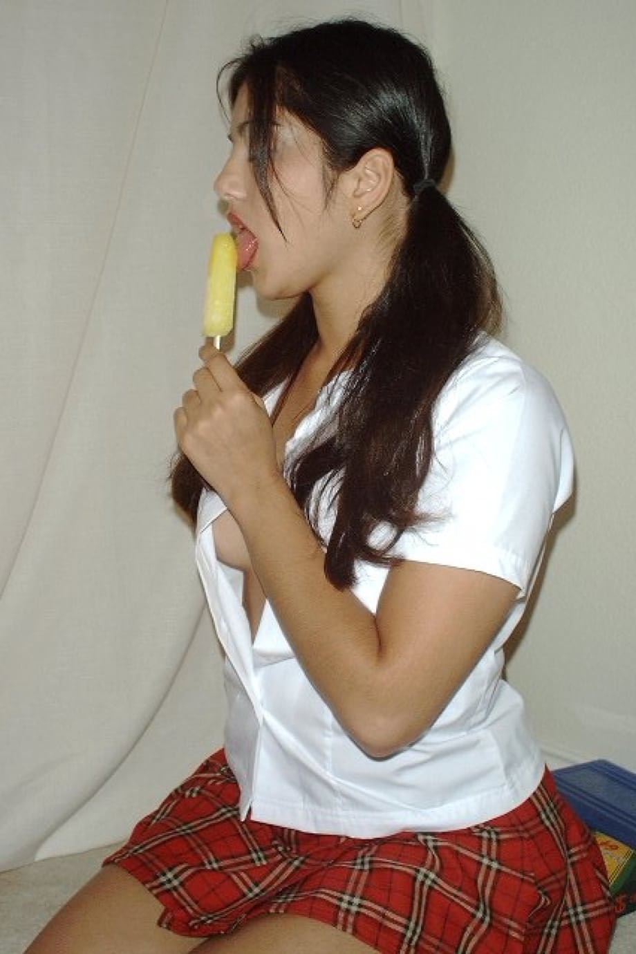 Pigtailed Indian honey Sunny Leone rubs her twat while eating a popsicle