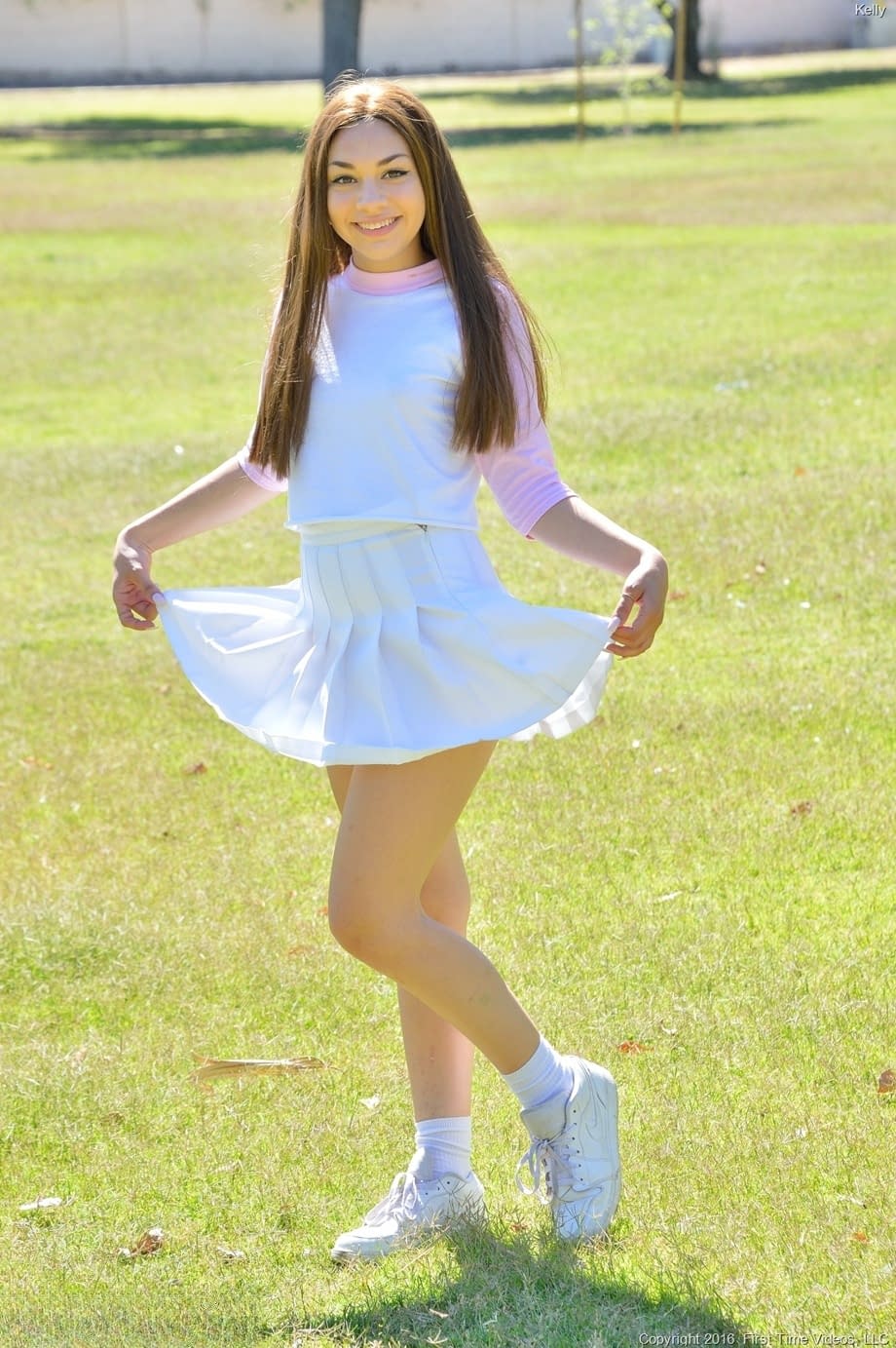 Brunette cutie Kelly reveals her tiny tits and fingers her snatch in the park