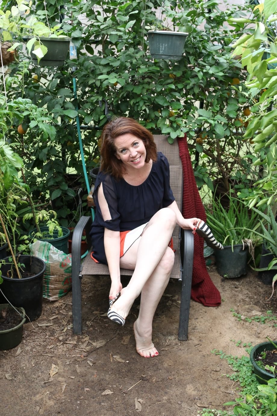 Busty mature lady Brie playing with her bald pussy in the garden