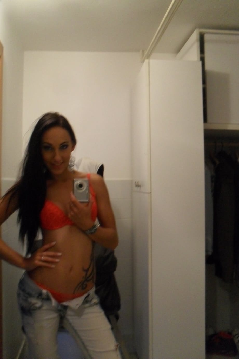 Teen with an inked body Ella Storm takes selfies while stripping in the mirror