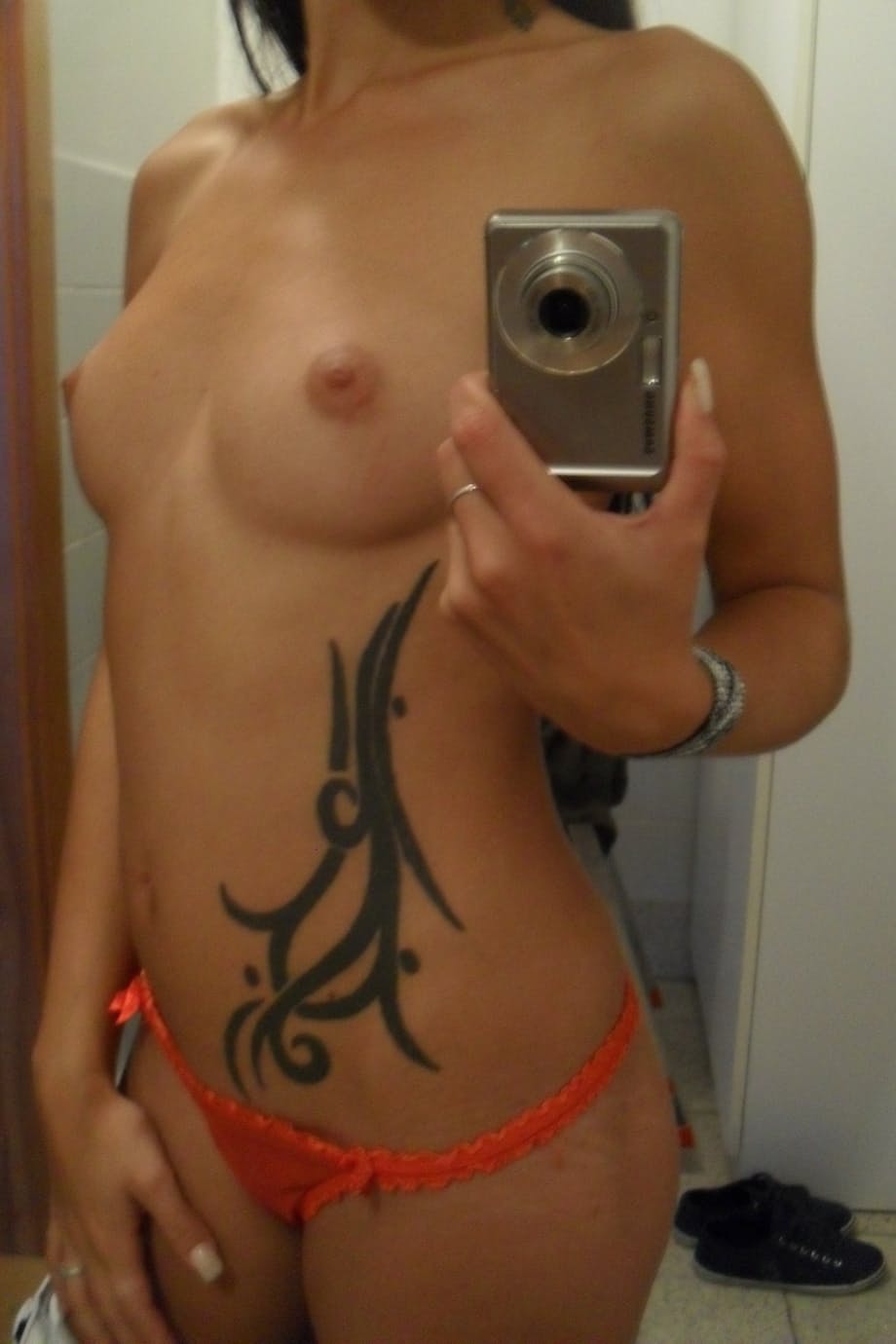 Teen with an inked body Ella Storm takes selfies while stripping in the mirror